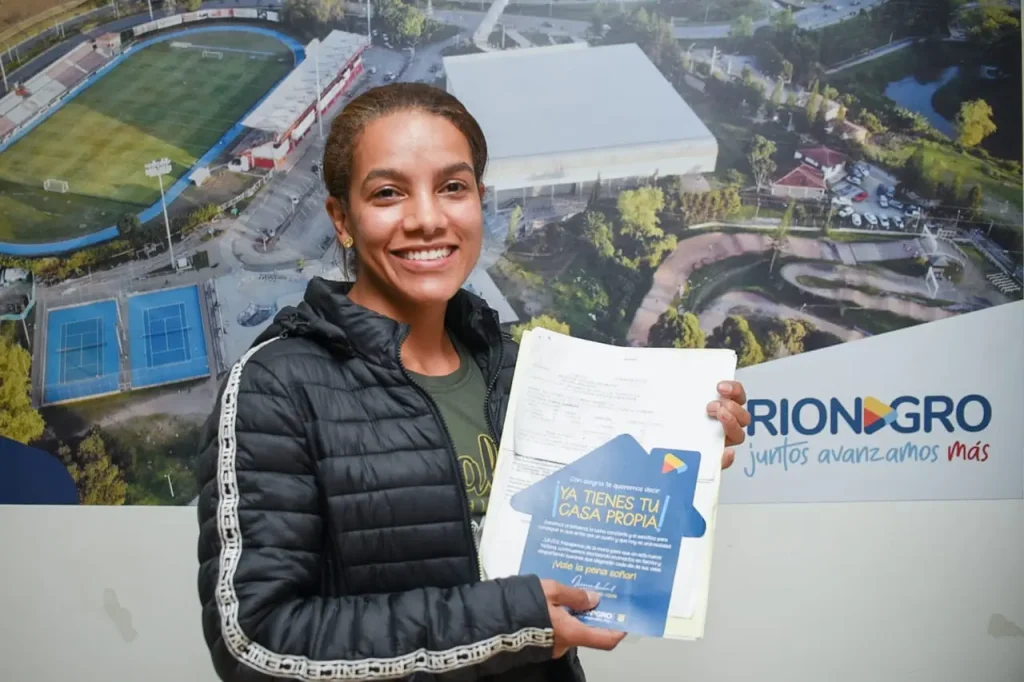 Edeso, galería proyectos de vivienda de la EDESO, mujer sonriendo mostrando su certificado de Ya tienes tu casa propia